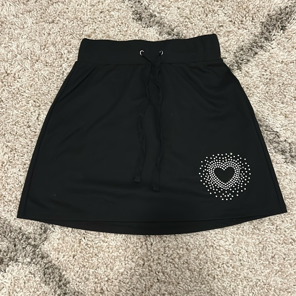 Cute black skirt with a rhinestone heart.
